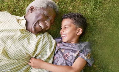 Young child laughing with an elderly man